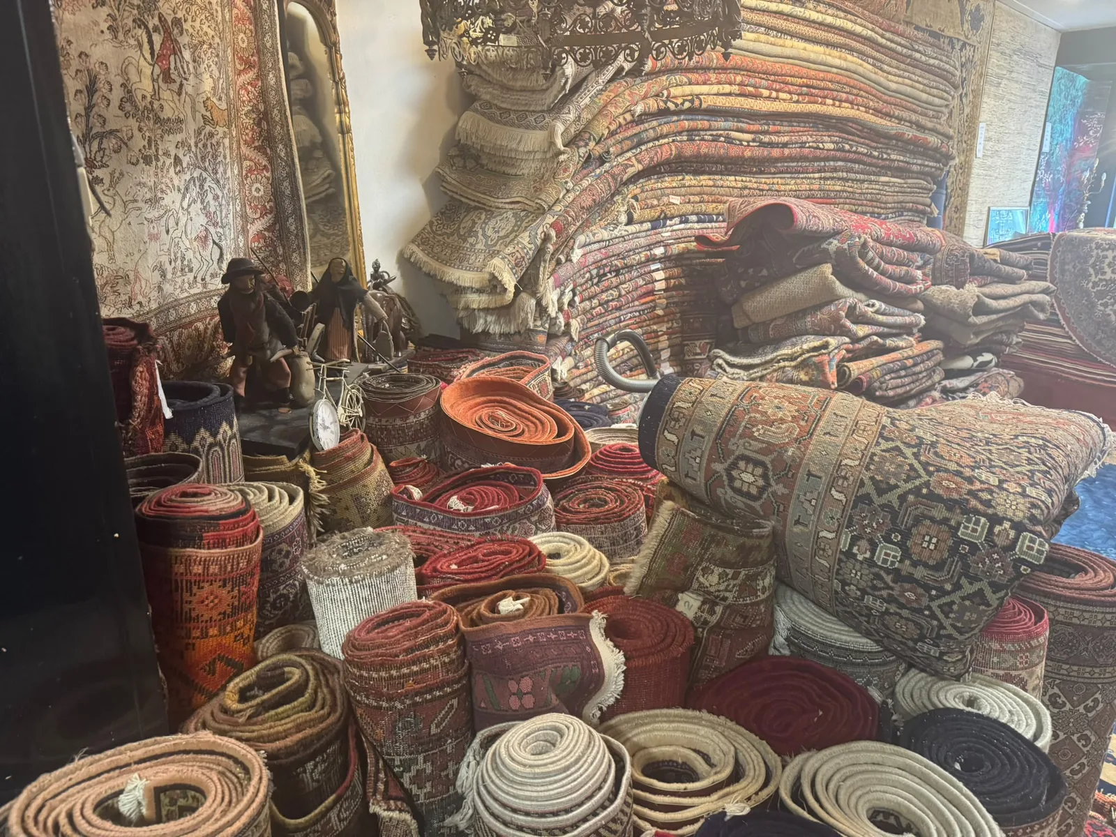 Metershoge stapels handgeknoopte Perzische tapijten in de showroom van Davoud in Amsterdam